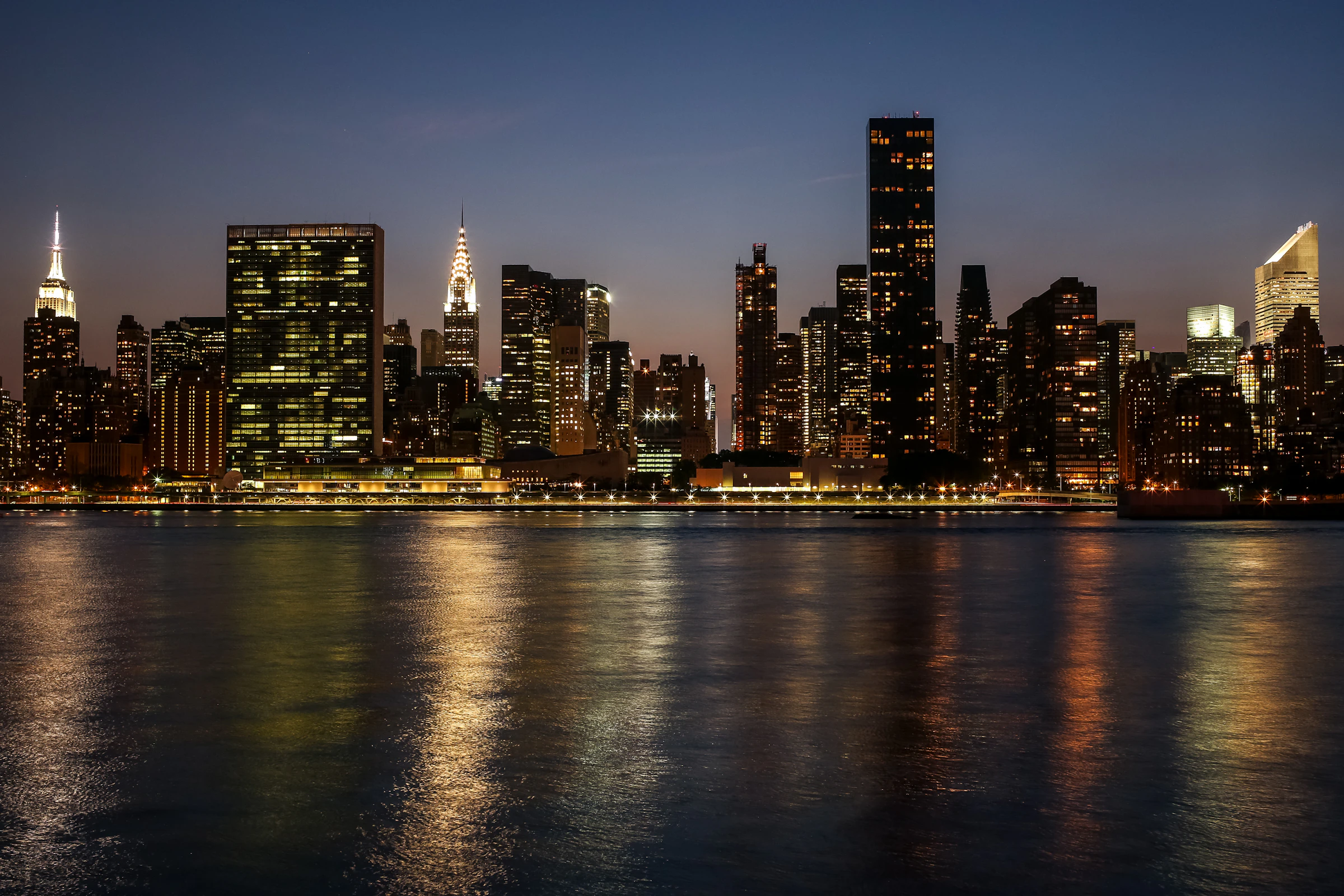 A city skyline lit up at night across the water